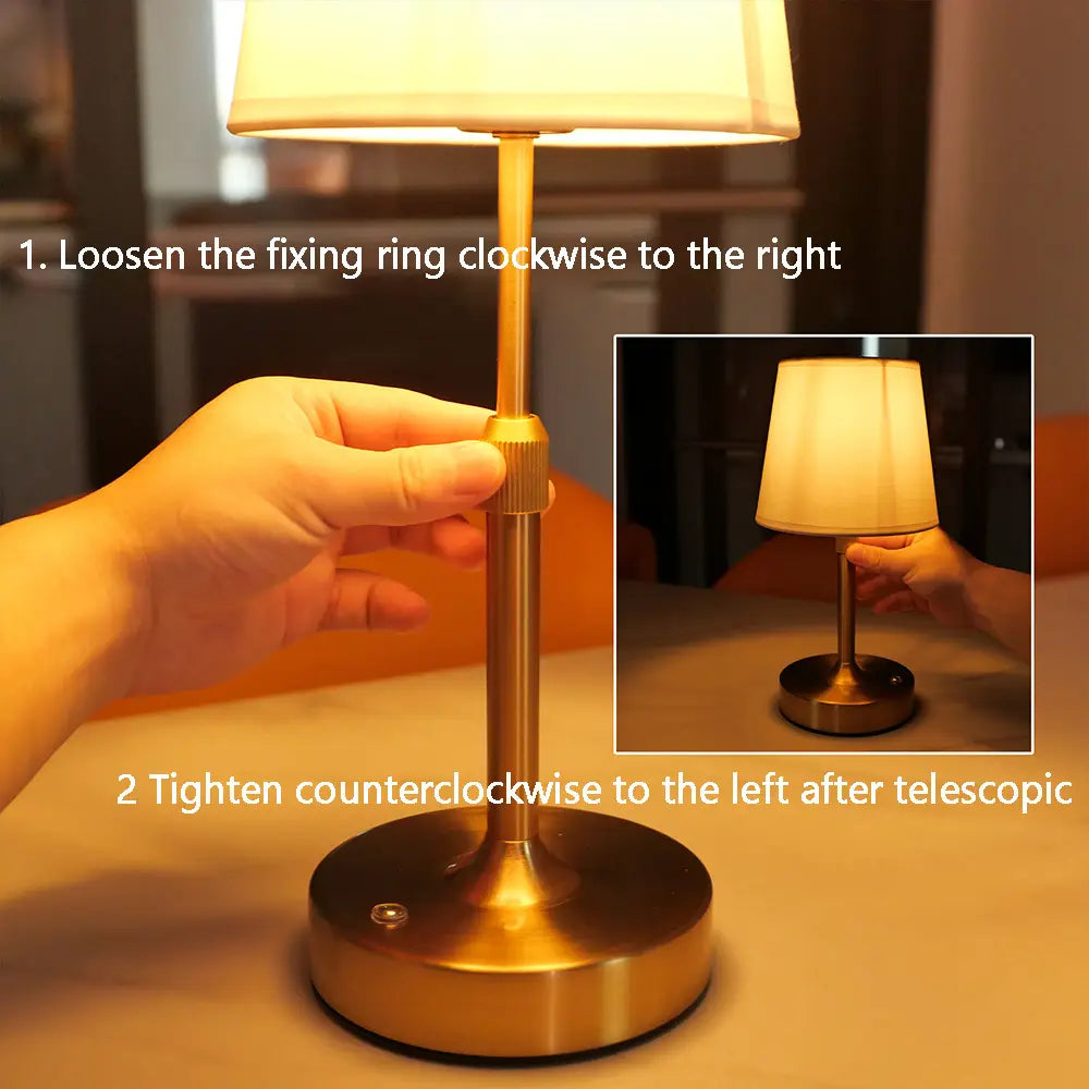 Messingveredelte teleskopische Touch-Tischlampe mit einem cremefarbenen plissierten Stoffschirm, aus dem vorderen Winkel dargestellt.