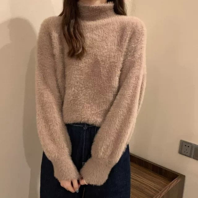 A soft fluffy beige fuzzy turtleneck sweater for women with long sleeves made from warm knit material ideal for winter wear.