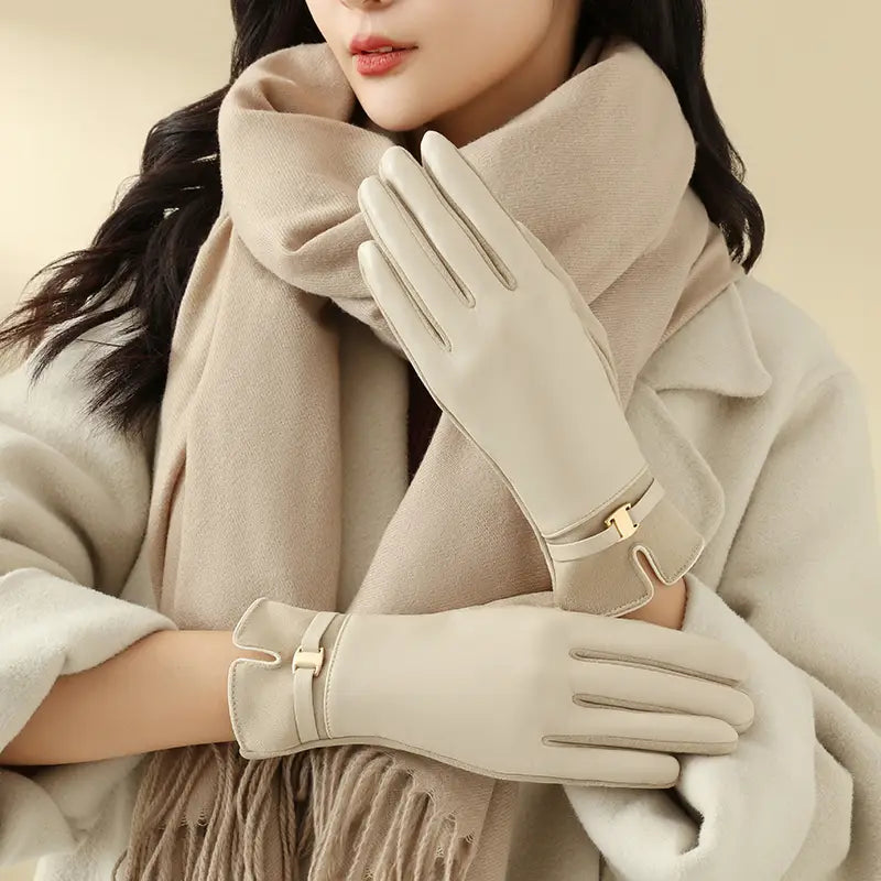 Beige Damen-Lederhandschuhe aus Leder für den Winter mit goldfarbenen Schnalldetails, von der Rückseite gezeigt, ausgelegt für die Verwendung mit Touchscreen.