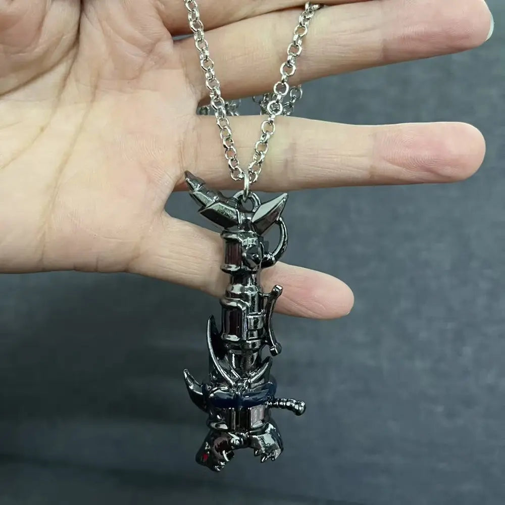 A sleek black metallic gaming pendant shaped like a stylized armored creature with sharp angular features and glowing red eyes suspended from a silver chain in the Jinx Cannon anime keychain collection.