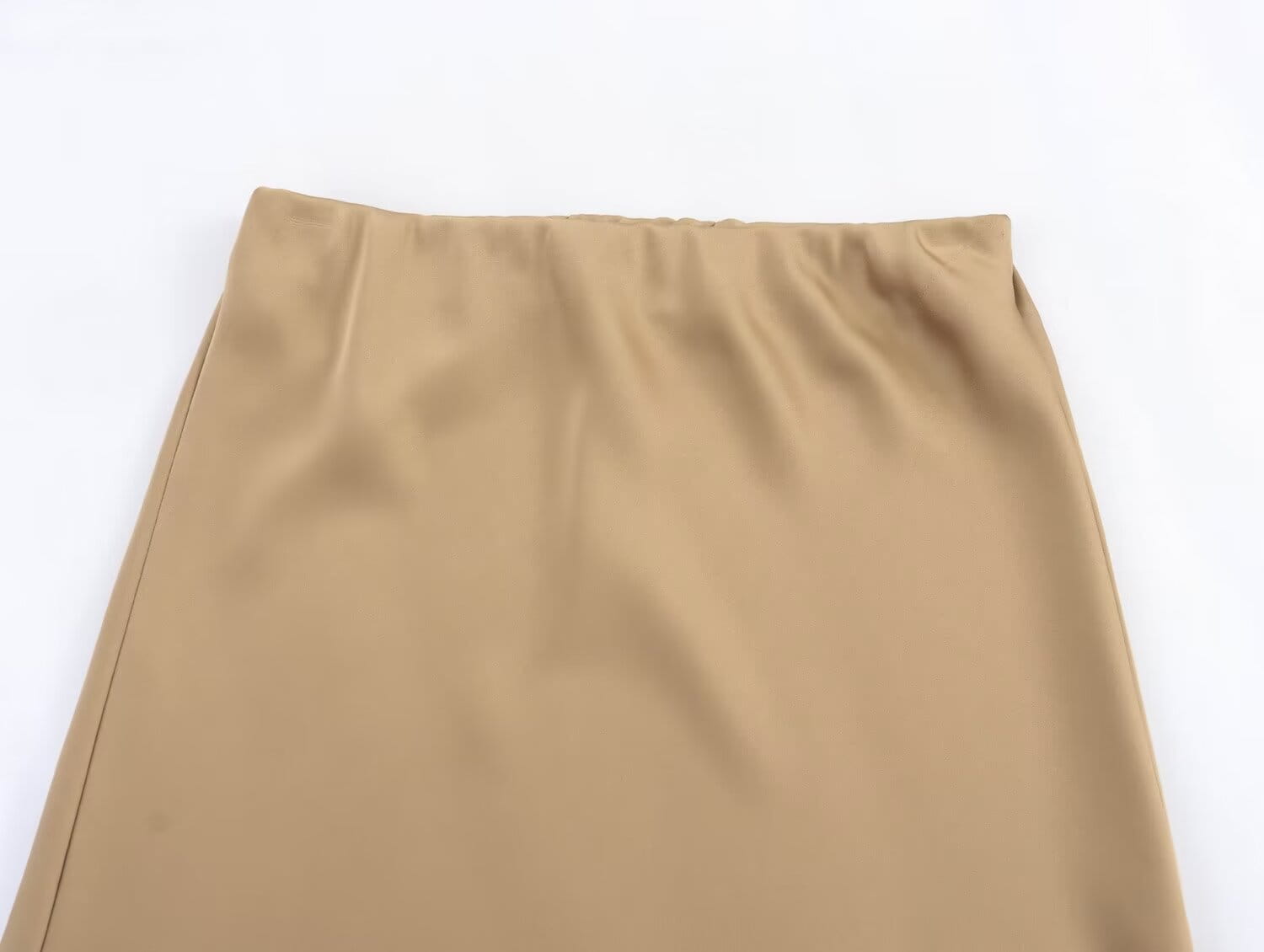 Une jupe midi en satin taupe, à taille haute, texture lisse, ceinture ajustée et plis subtils, pour une allure élégante.