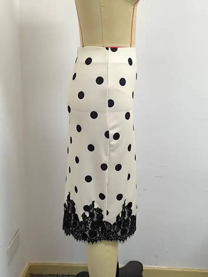 Una falda lápiz blanca con lunares negros y ribete de encaje negro en el dobladillo, con diseño de longitud midi