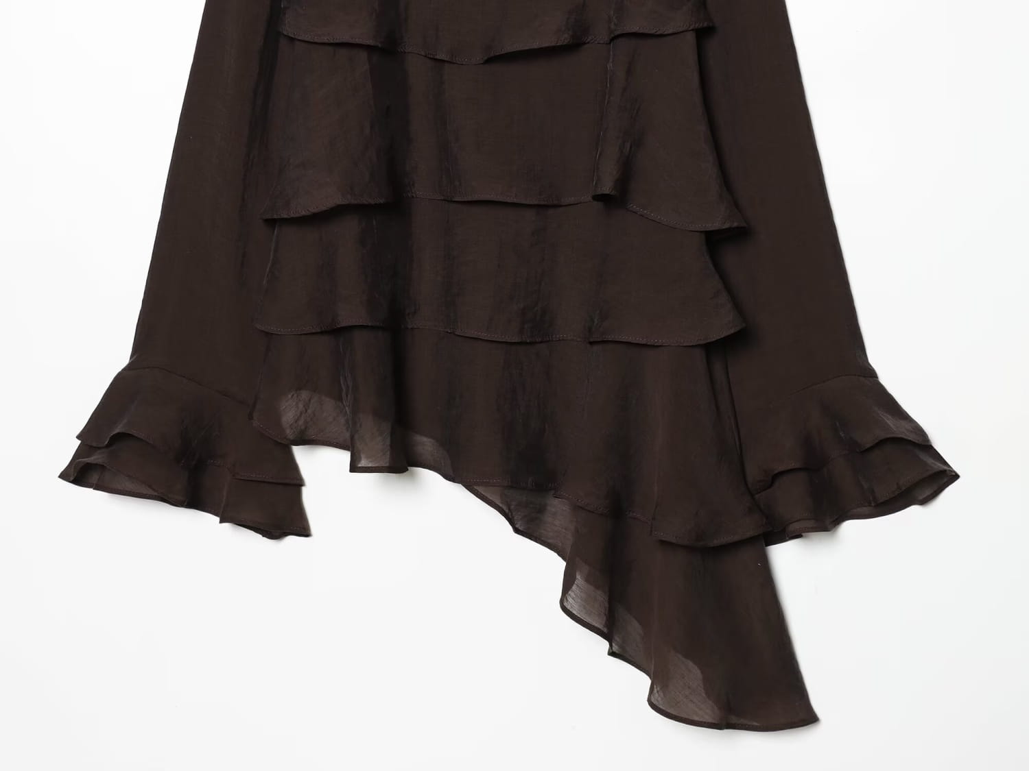 a flowing black ruffled skirt with sheer fabric and layered asymmetrical hemline paired with a brown chiffon flare sleeve blouse highlighting the sleeve style