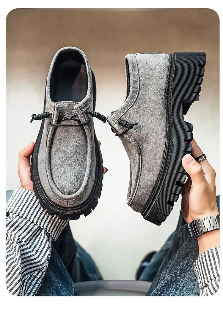 Mocassins en suède gris à semelles en caoutchouc noir épaisses et lacets réglables, conçus comme des baskets décontractées à plateforme en suède à semelle épaisse pour hommes.