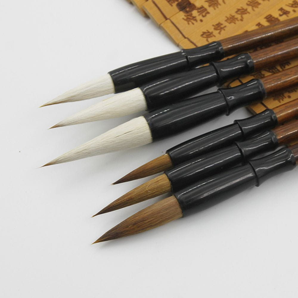 Set of six traditional Chinese calligraphy brushes with natural bristles, black lacquered handles, and wooden shafts for writing practice.