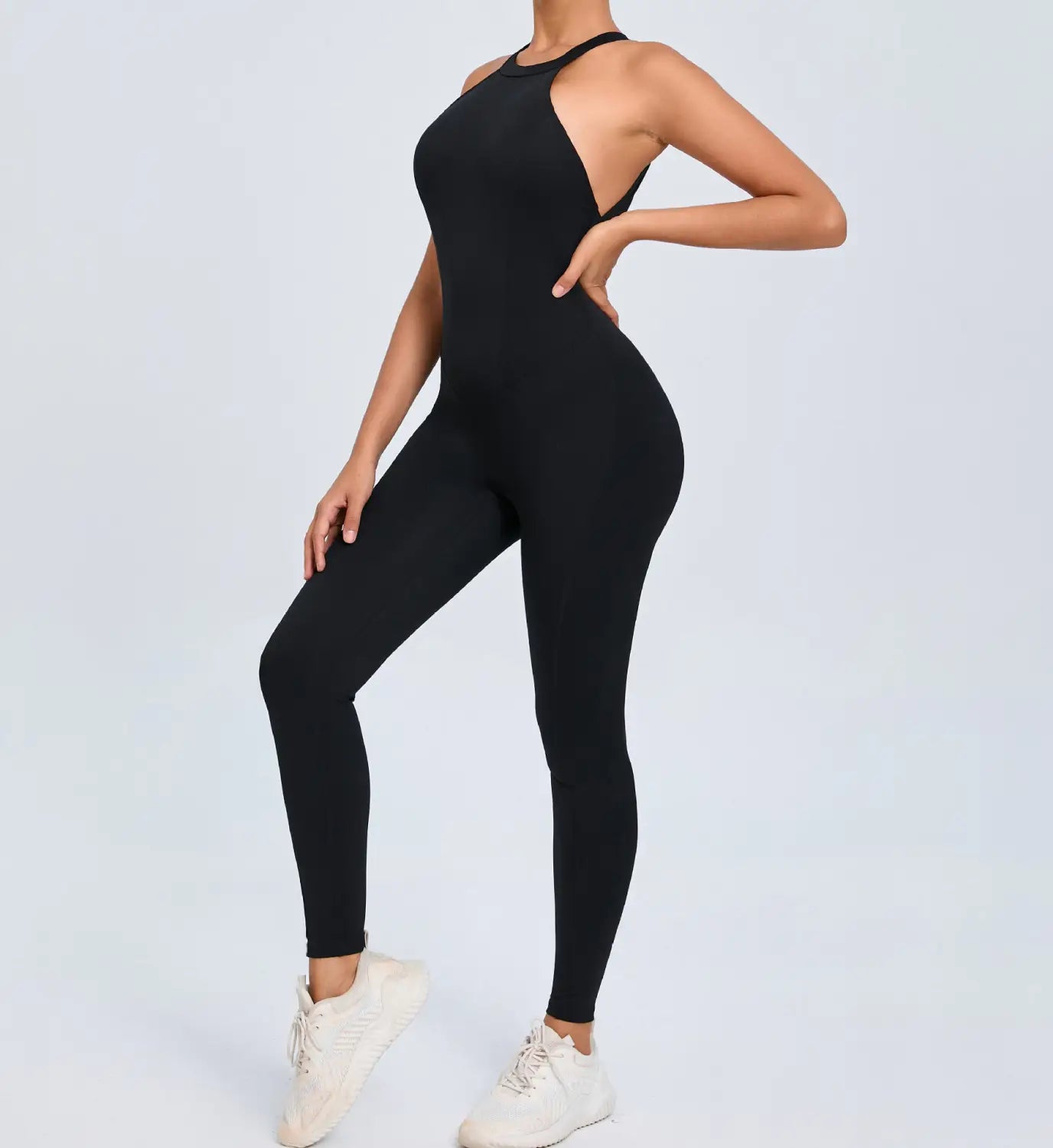 Black form-fitting one-piece athletic jumpsuit with a high neckline and cut-out shoulder detail designed for workout use