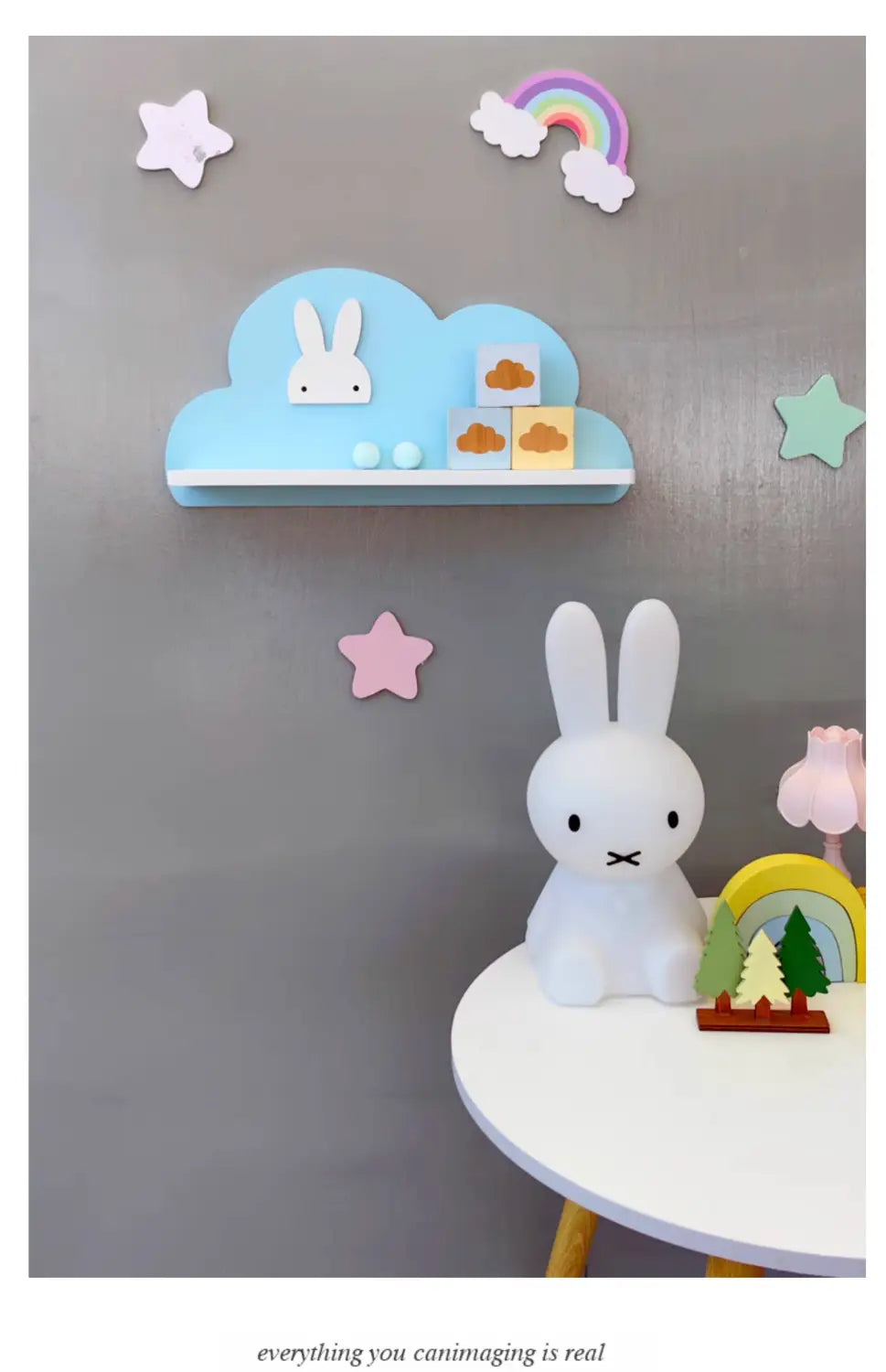 Eine weiße Miffy-Lampe mit weichen, gerundeten Ohren und einem minimalistischen Gesichtsausdruck, die auf einem Regenbogen-Wolken-Bücherregal aus Holz für Kinder an der Wand platziert ist.