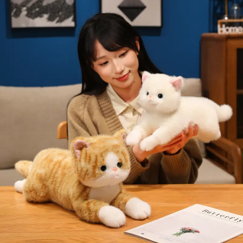 A plush white kitten stuffed animal toy with soft fur and pink inner ears held gently in hands as a cute plush toy pillow.