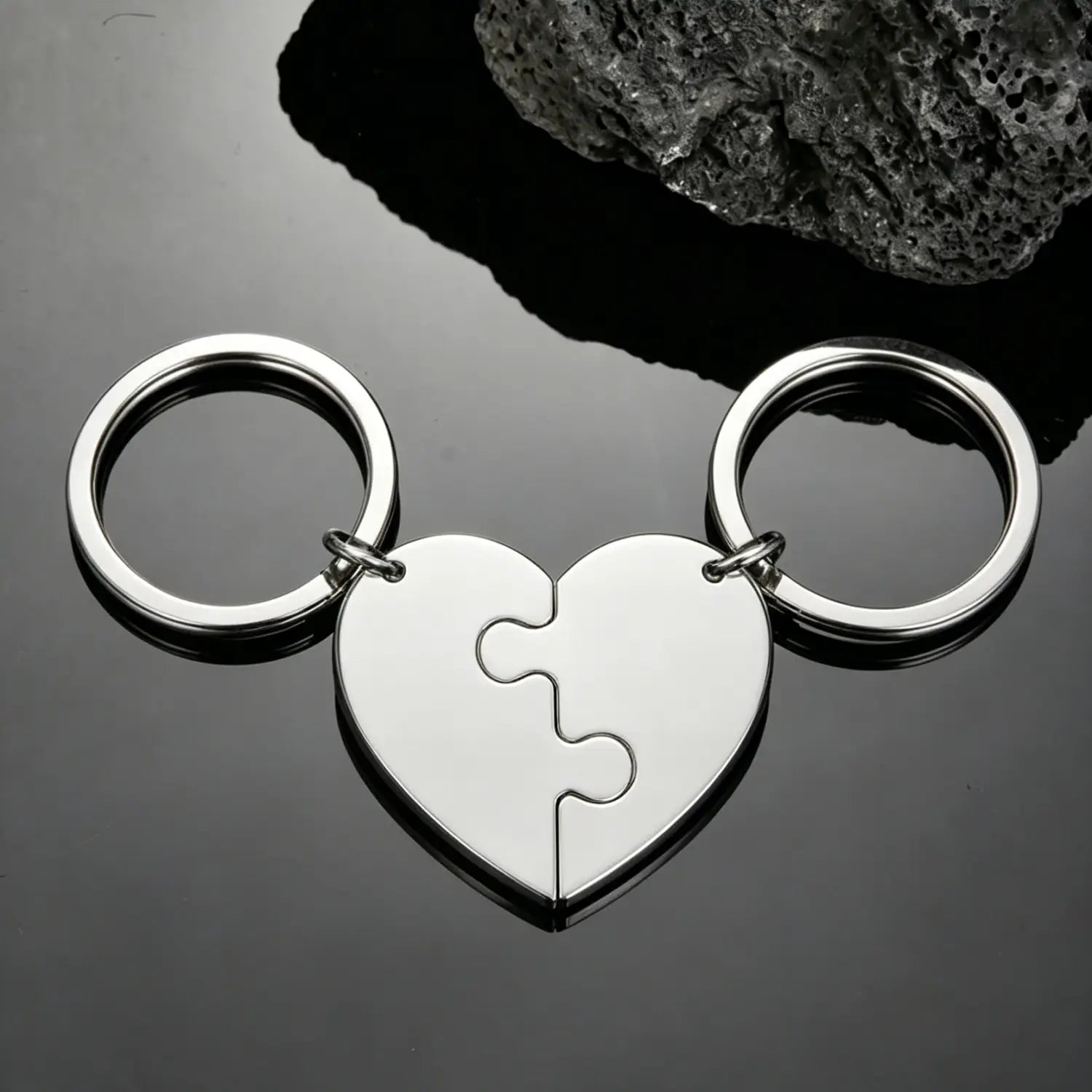 Silver heart-shaped keychain made of metal featuring two interlocking puzzle-piece halves each attached to a circular ring for the custom family puzzle heart keychain.