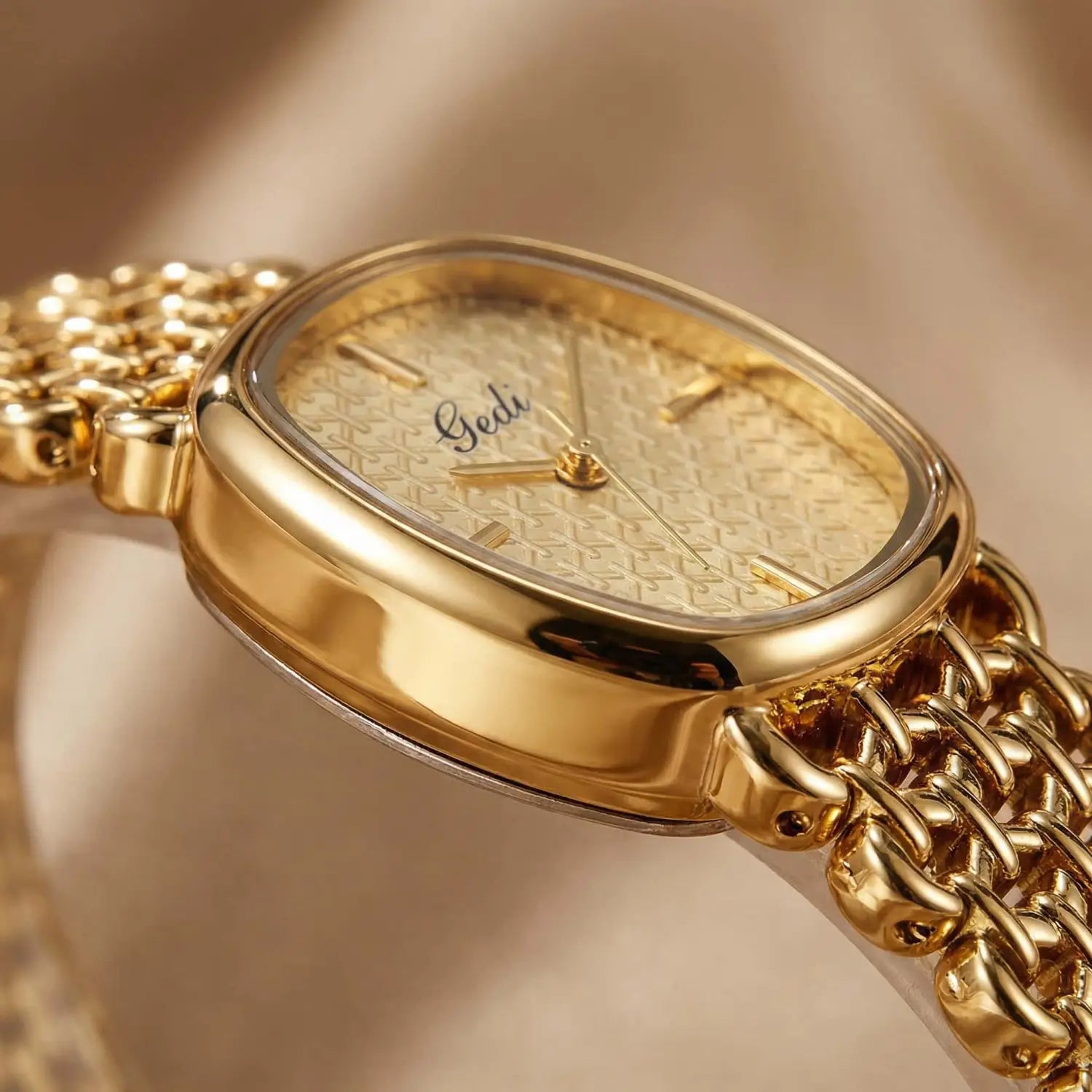 Gold-toned gedi women watch with an oval face featuring a textured light gold dial and a matching mesh bracelet elegant quartz timepiece.