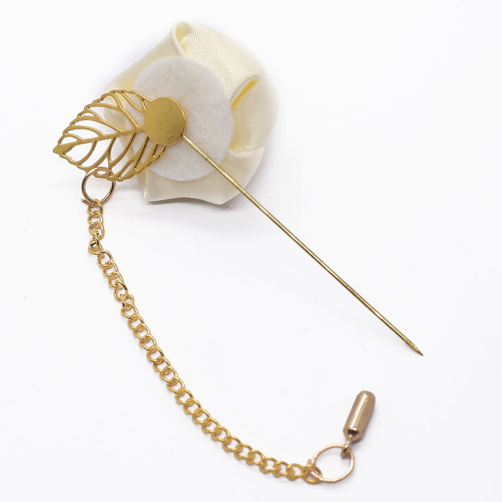 Boutonnière de rose bordeaux comportant une délicate épingle en forme de feuille au ton doré, une fleur en tissu de couleur crème et une chaîne dorée fixée.