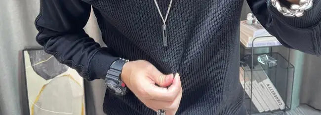Pull-over en maille à empiècement contrastant pour homme, manches longues, noir en maille côtelée, avec un motif texturé discret et des manches longues.