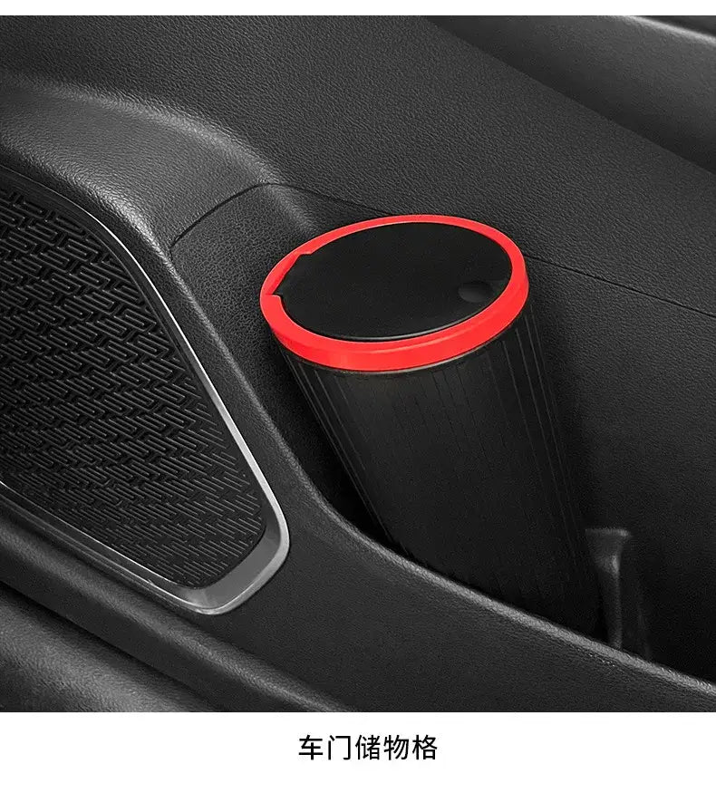 papelera cubo de almacenamiento para basura del automóvil de tipo de prensado cilíndrica negra con un vibrante borde rojo, mostrada desde un ángulo frontal.