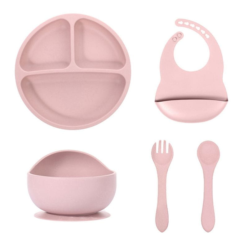 pink silicone baby feeding set with suction base featuring a three-compartment plate, suction bowl, bib, and utensils for infant mealtime use