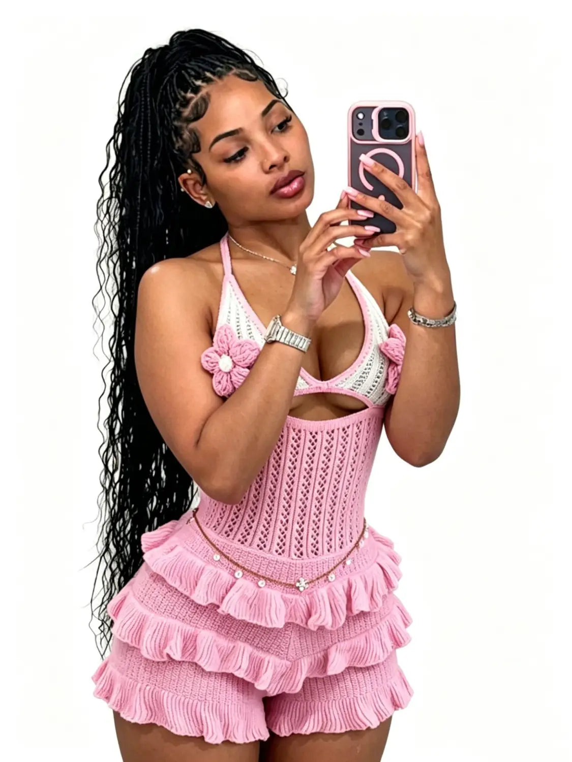 Pink knitted romper with floral embellishments and ruffled layers designed as a halter summer playsuit.