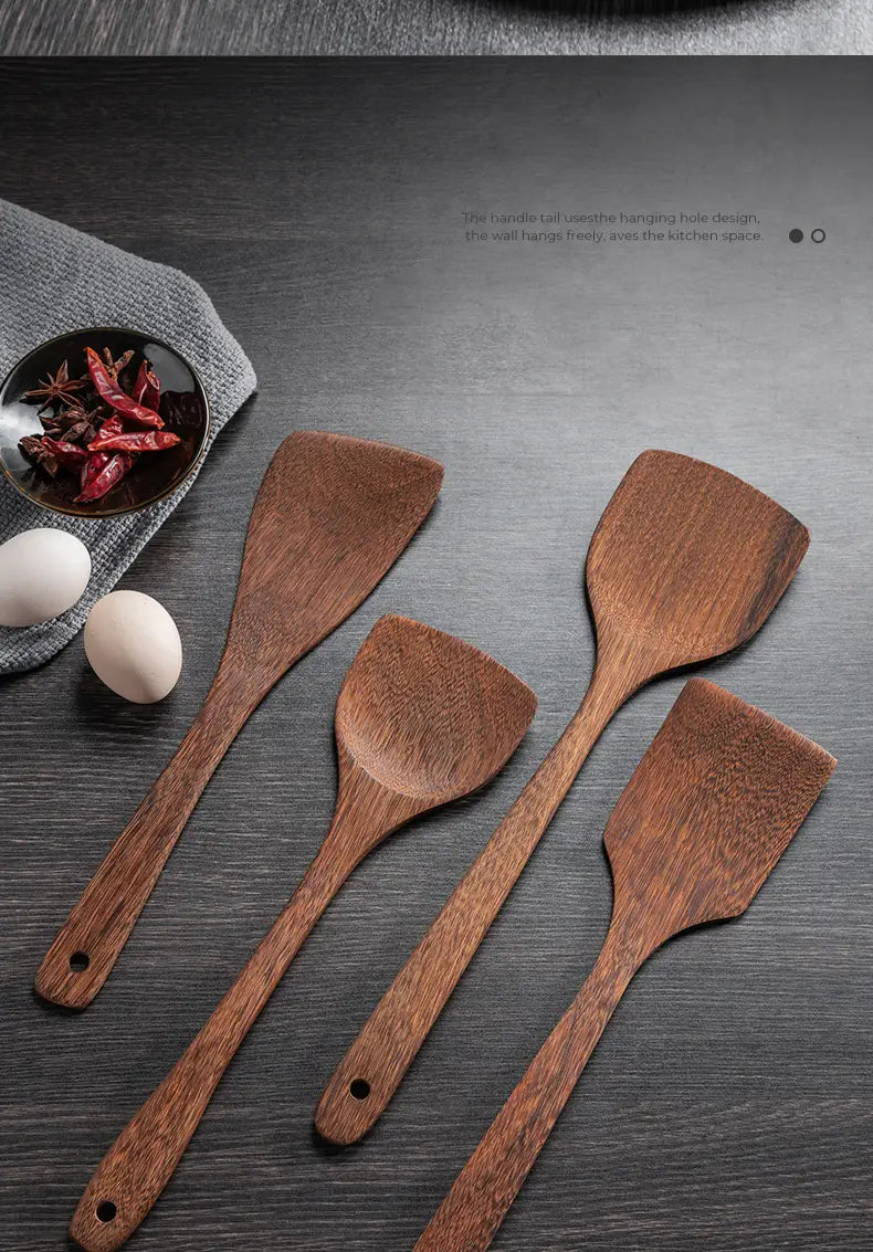 Set of four wooden cooking spatulas with smooth natural wood grain rounded handles and hanging holes for non-stick cookware use.
