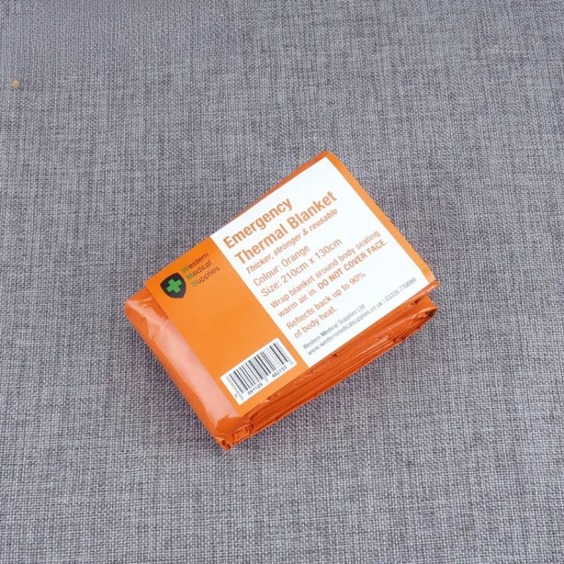 Orange emergency thermal blanket made of reflective material in a compact sealed plastic wrapper with printed product details for survival gear use.