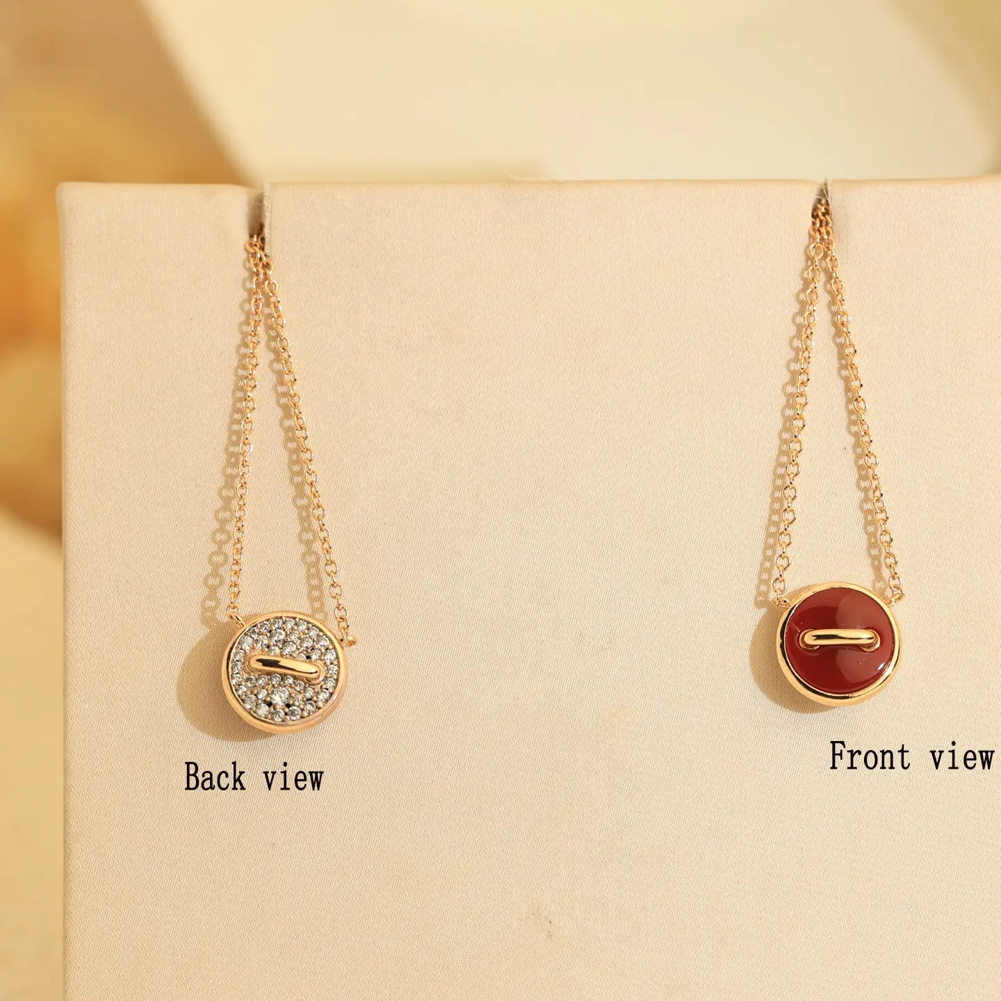 Collier bouton double plaqué en or rose en argent sterling, présentant deux pendentifs de forme bouton ton sur ton, dont une face sertie de diamants et une face finition émail rouge lisse.