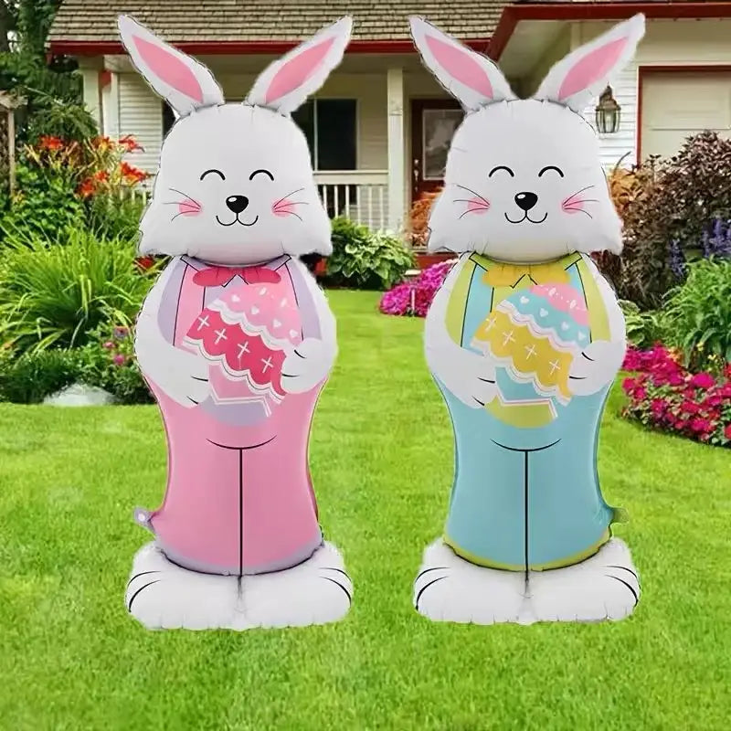 Deux décorations de fête de ballons-bijoux en feuille « lapin de Pâques » gonflables, présentant une fourrure blanche avec des oreilles intérieures roses : l’une est rose avec un nœud assorti et l’autre est en combinaison bleu clair tenant des paniers à œufs colorés.
