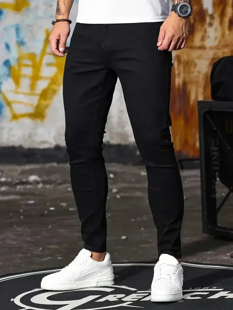 Jeans en denim bleu foncé coupe slim pour homme présentant un design moderne et élégant, avec des détails de coutures subtils.