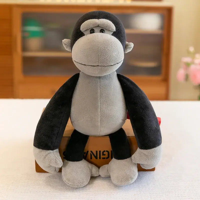 un animal de peluche de un gorila negro y gris, hecho con tela de textura suave, adecuado para niños, junto con una colección de juguetes blandos de león, elefante y tigre