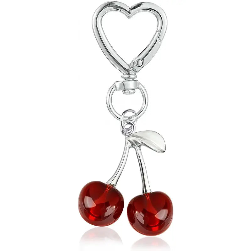 Silver heart-shaped keychain with two glossy red cherry charms designed as a cherry bag charm heart keychain.