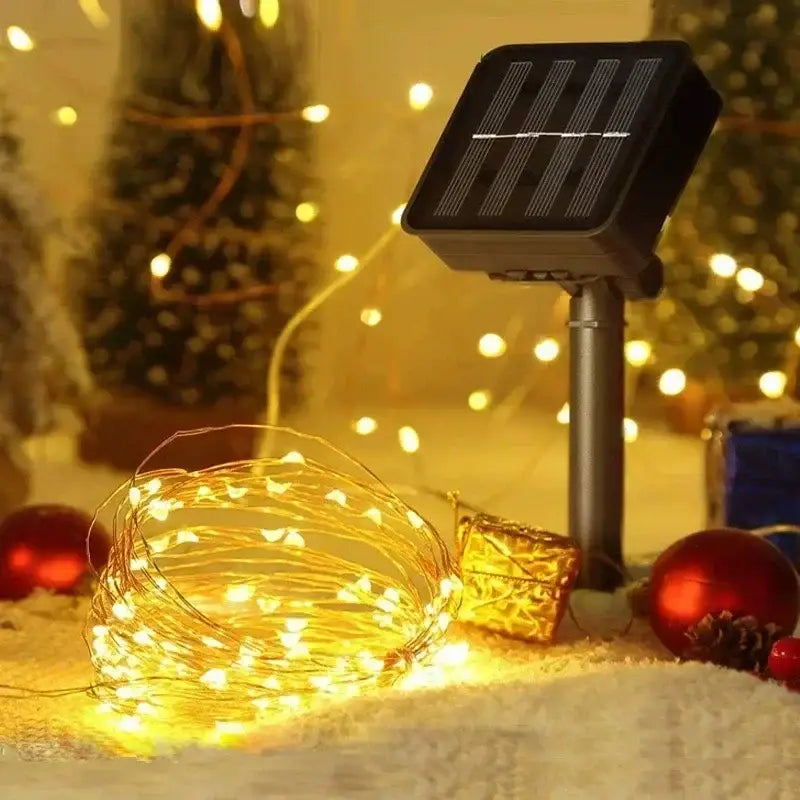 guirlande de lumières à fils de cuivre solaire pour extérieur à DEL noire avec ampoules à DEL blanc chaud, enroulées et allumées sur une surface enneigée