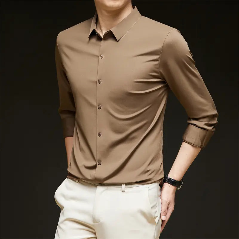 Una camisa de vestir para hombre sin arrugas color beige, elegante, con mangas largas, cuello impecable y puños enrollados con esmero.