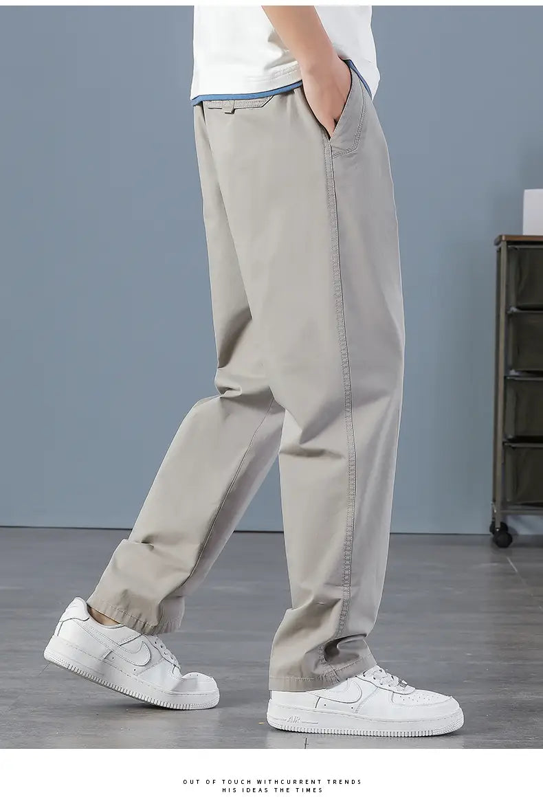 Beige cotton relaxed fit men cargo pants with elastic cuffs and utility design.