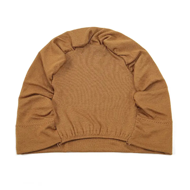 A soft tan-colored knit stretchy jersey hijab cap with ribbed texture and elasticated hem.