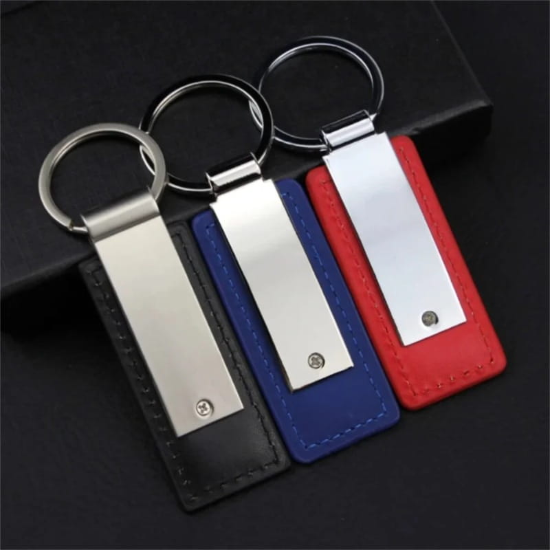 Three rectangular leather keychains in black blue and red with silver metallic accents for custom couple personalized matching gift.