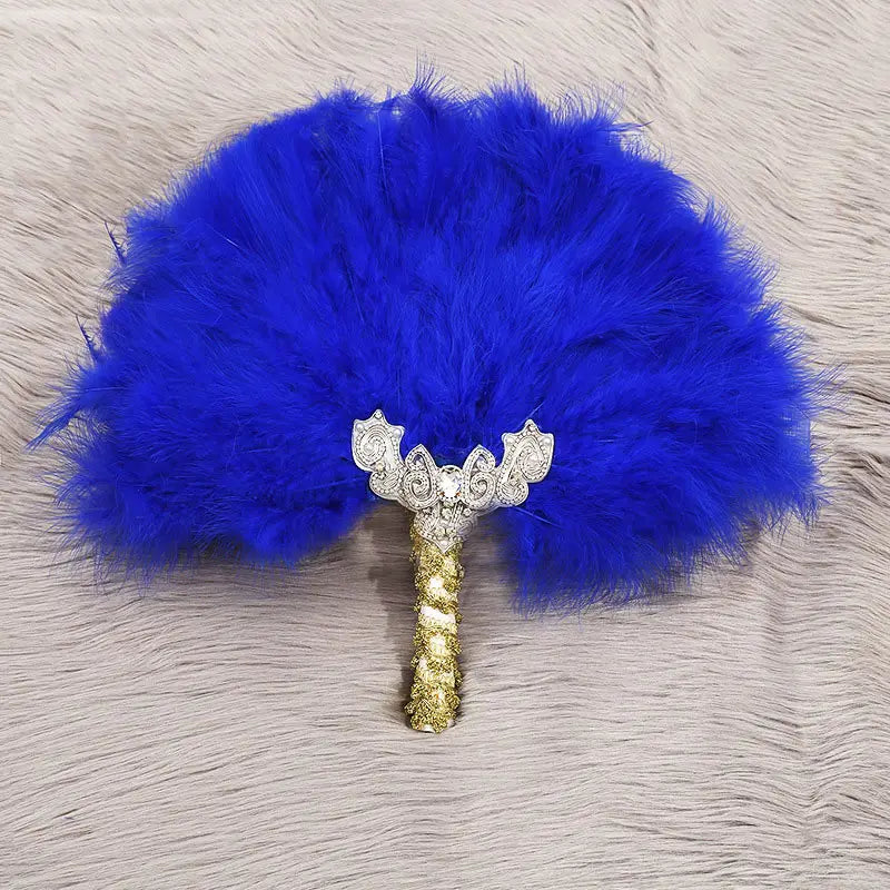 Leuchtend königsblauer Feder-Fächer für die Hochzeit mit einem kunstvollen silber- und goldfarbenen Griff, der mit detailreichen Verzierungen versehen ist, zur Verwendung als Requisit beim Brauttanz.