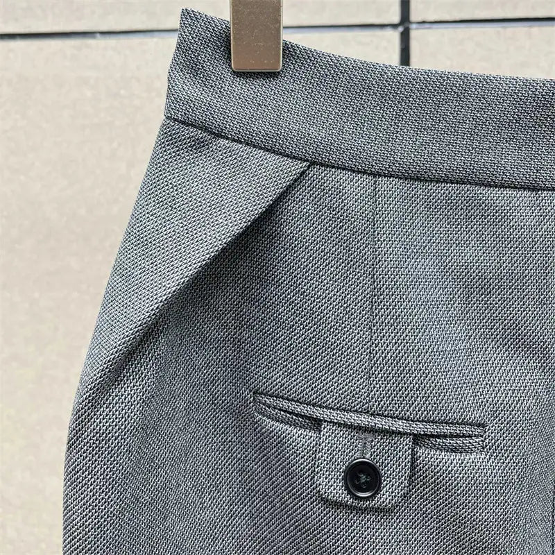 Jupe crayon grise taille haute avec tissu en laine gris texturé et poche à rabat fermée par des boutons, vue depuis l’arrière