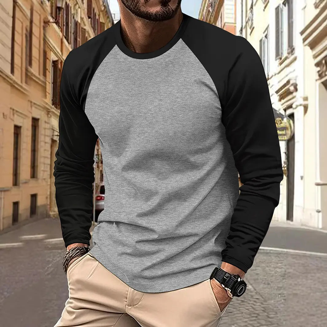 T-shirt raglan à manches longues pour homme, avec un corps gris chiné et des manches noires, présentant un design classique à encolure ronde, adapté à une tenue de printemps décontractée.