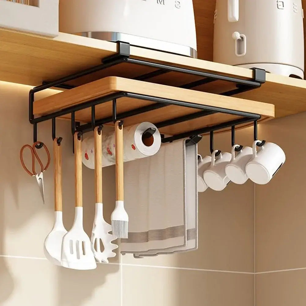 Hängender Küchenorganizer aus Holz und schwarzem Metall mit Haken, die weiße Utensilien, Becher, eine Küchenpapierrolle sowie ein gestreiftes Geschirrtuch halten; ausgelegt für die Aufbewahrung von Schneidebrettern und Topfdeckeln.