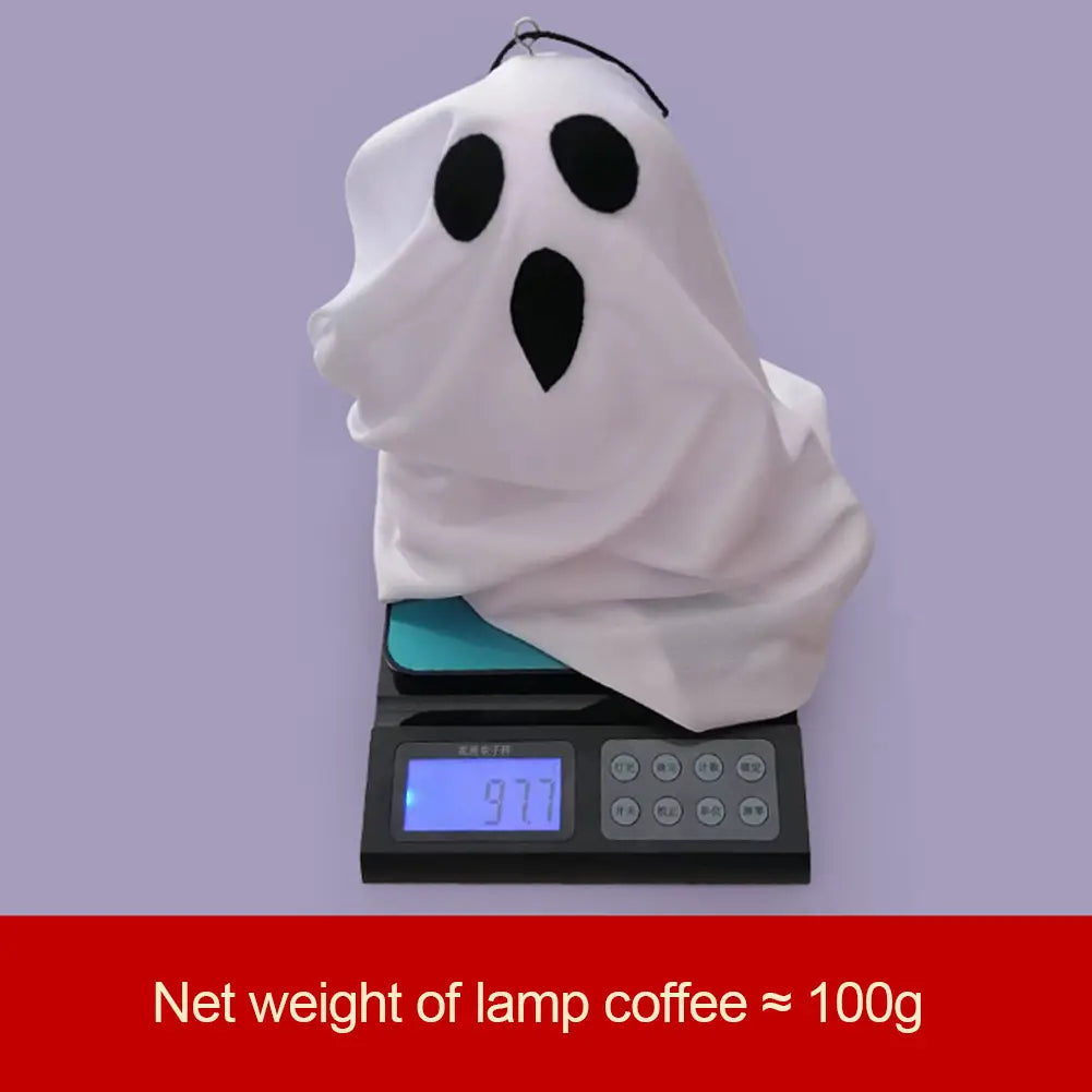 Led hanging ghost halloween decoration made of white fabric with black embroidered eyes and mouth hanging from a small loop.