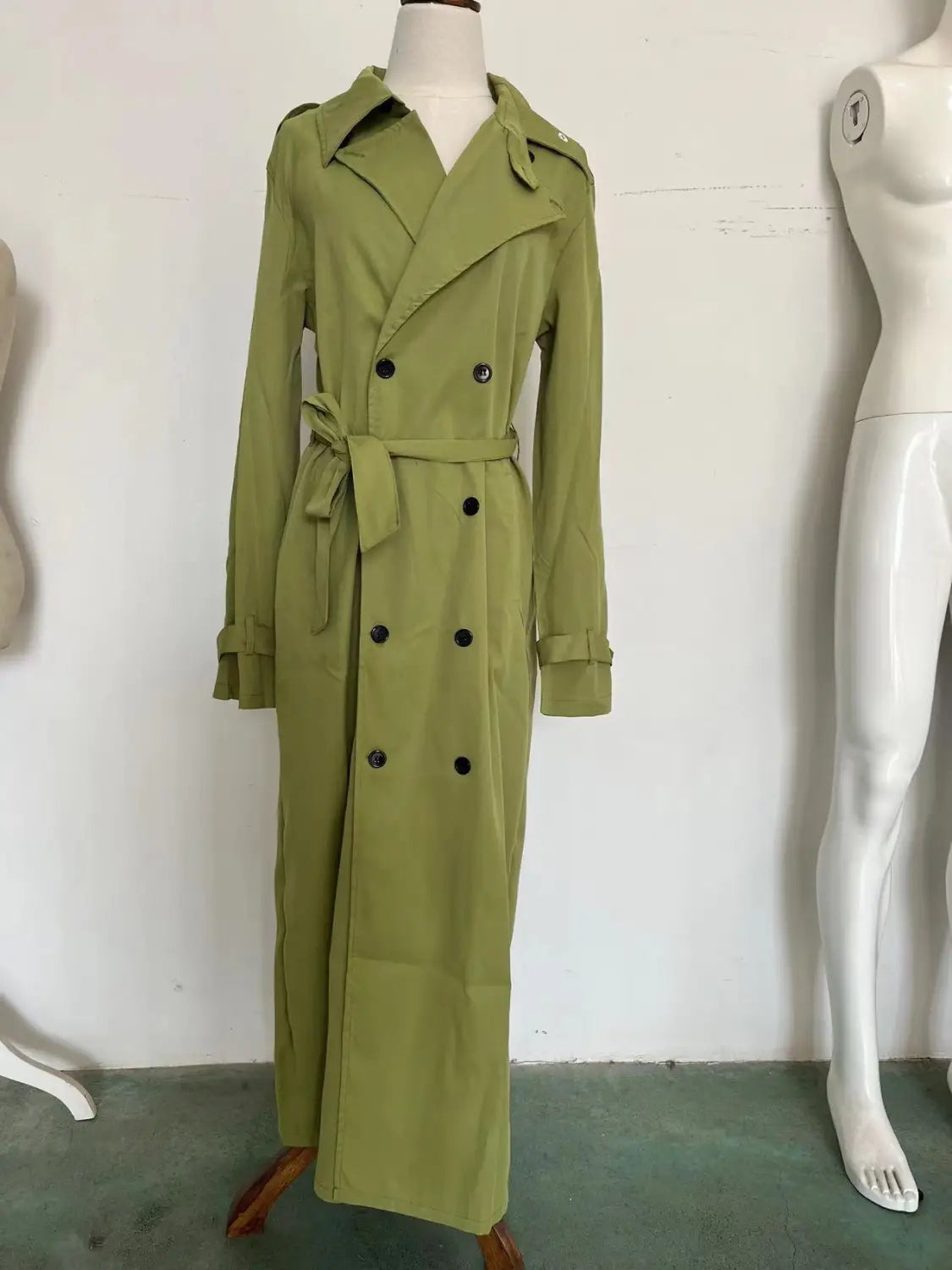 Herren-Langmantel in Olivgrün mit Doppelreiher-Design, schwarzen Knöpfen und passendem Gürtel für Business-Casual-Kleidung.