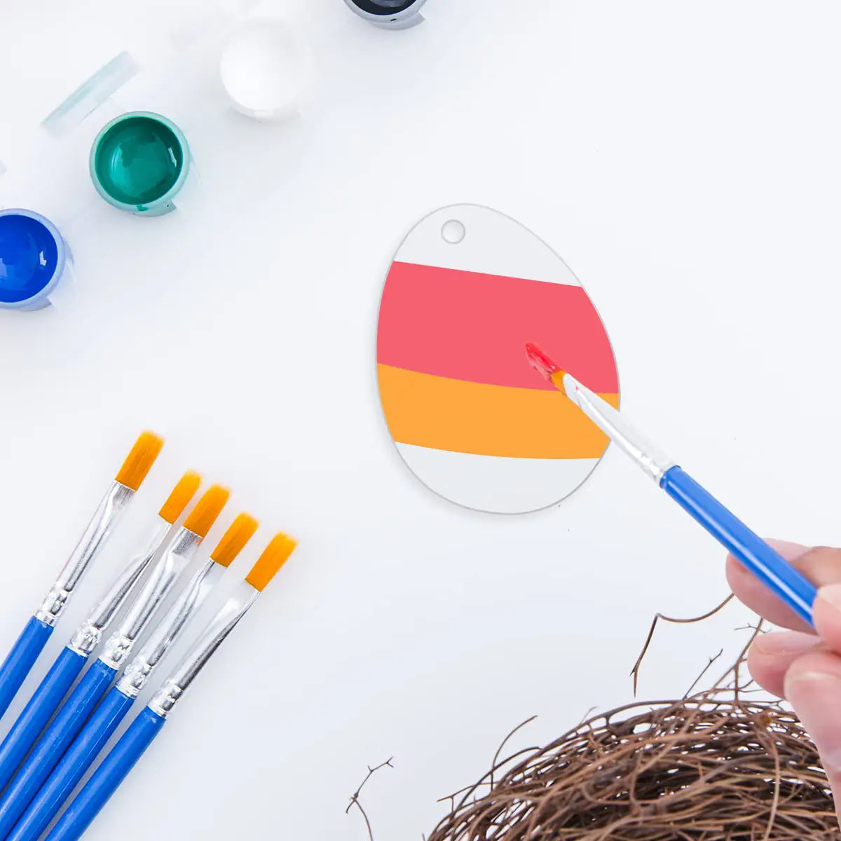 Ornement vierge en acrylique pour œuf de Pâques, peint à la main, avec des bandes horizontales rouges et orange sur une base blanche, peint au pinceau.