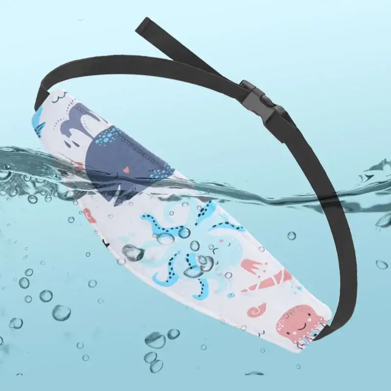 ein weißer wasserdichter Kopfstützriemen für einen Babyschalen-Sitz verstellbarer Schlafpositionierer mit einem verspielten Unterwasser-Design, das Cartoon-Sharks, Oktopusse und Seepferdchen in Blau, Pink und Grau zeigt