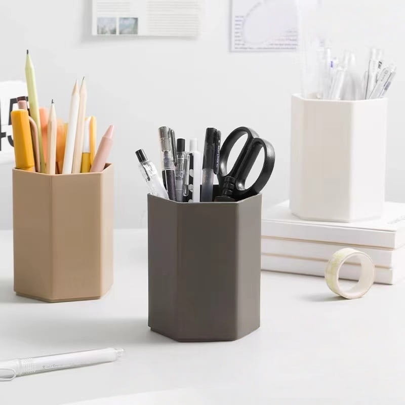 Porte-stylo en plastique hexagonal gris foncé pour bureau, rempli de stylos et de ciseaux, pour un usage au bureau.
