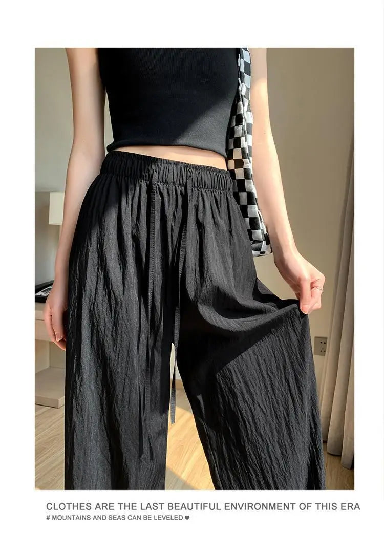 Schwarze weite Plissee-Hose für Damen aus leichtem, leicht gekräuseltem Stoff mit elastischem Bund, ideal für die Sommerzeit