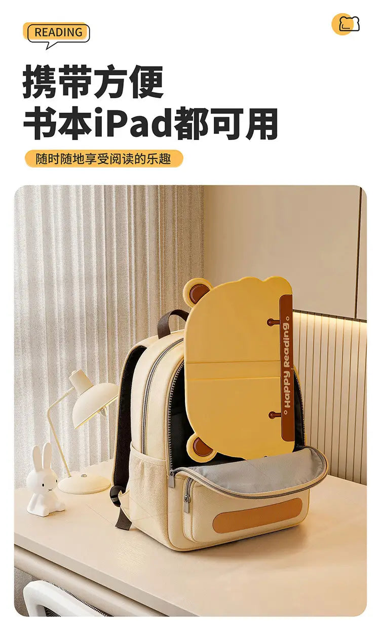 Cremefarbener Kinder-Bären-Lese-Stand als Buchhalter mit schwarzen Riemen und einem gelben bärenförmigen Tablet-Halter mit der Aufschrift „happy reading“.