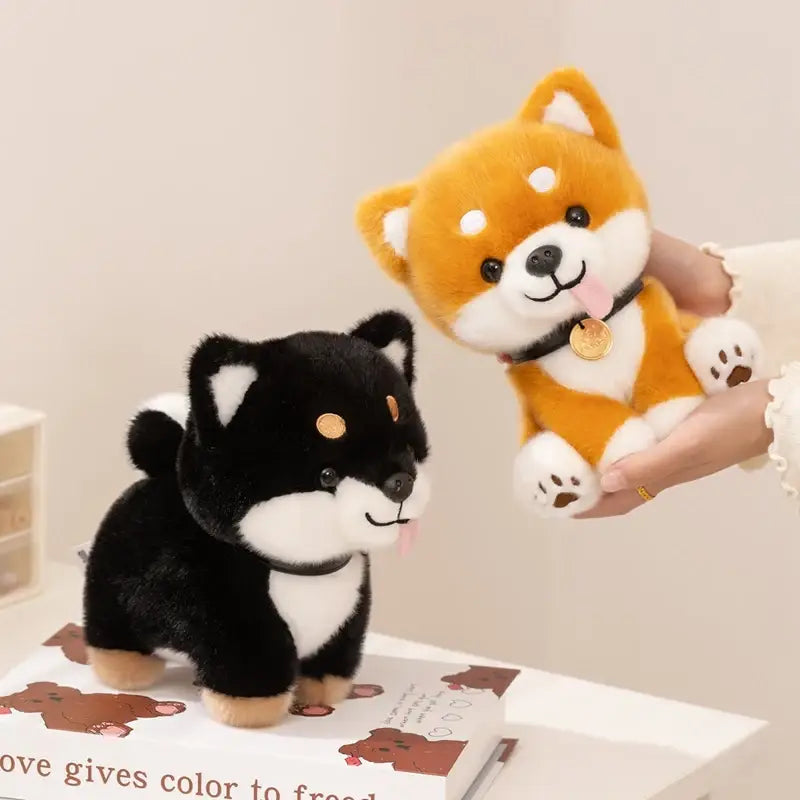 Adorable plush Shiba Inu dog stuffed animal toys featuring one black and white with tan paws and one orange and white with a gold coin charm on its collar.