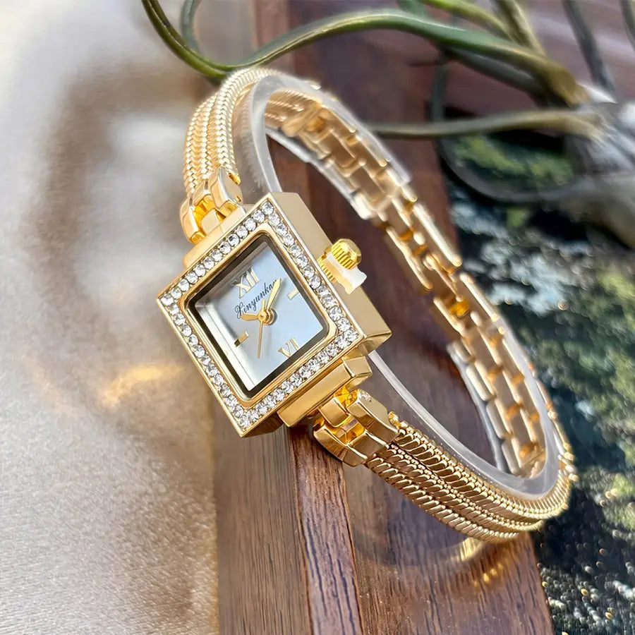 Gold diamond square watch with a gold-toned light blue dial featuring roman numerals and the brand name panyanke paired with an ornate braided metal vintage fringe strap.
