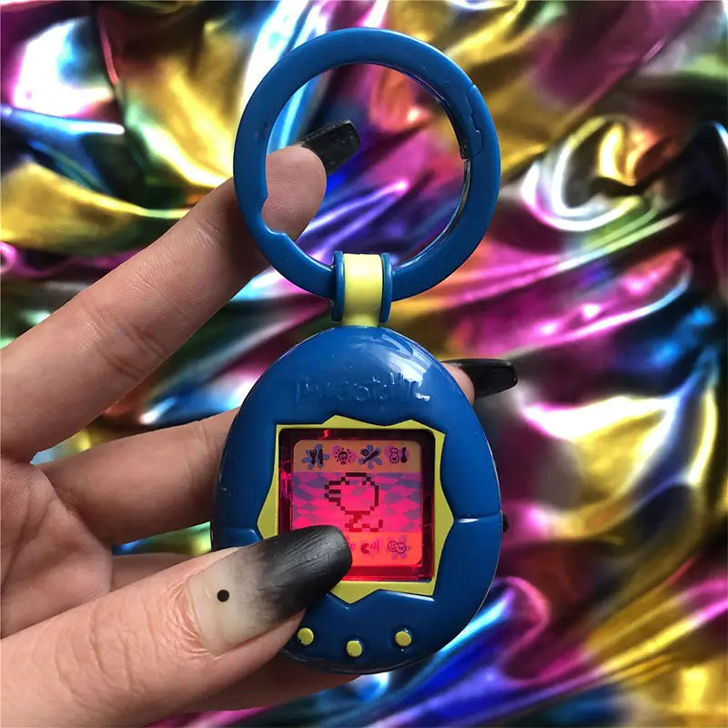 Blue plastic tamagotchi electronic virtual pet keychain 90s toy with a yellow border around the screen and three small yellow buttons below.