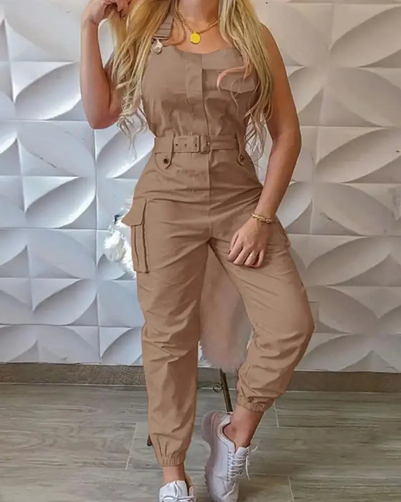 Combinaison cargo beige avec taille ceinturée et poches latérales, conçue comme une combinaison ample et décontractée.