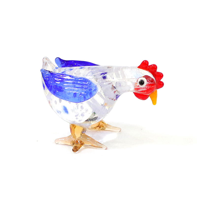 A translucent glass rooster miniature figurine Easter ornament with vibrant blue wings, a red comb and wattle, and amber-colored feet.