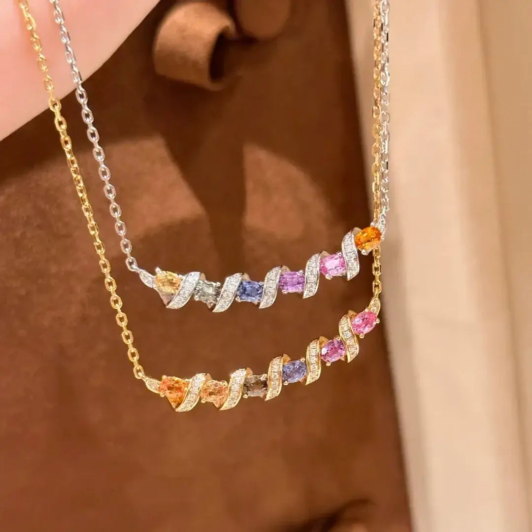 Deux élégants colliers à barreaux torsadés en argent, présentant des pierres précieuses colorées serties dans un métal ton or et argent, avec des accents de diamants pavés et un design de pendentif géométrique.