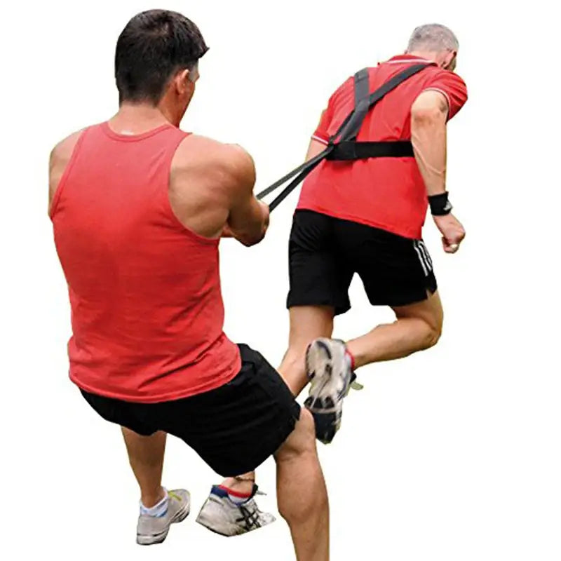man wearing a black agility training resistance band harness sled pull strap paired with a red shirt and black shorts shown from the back side