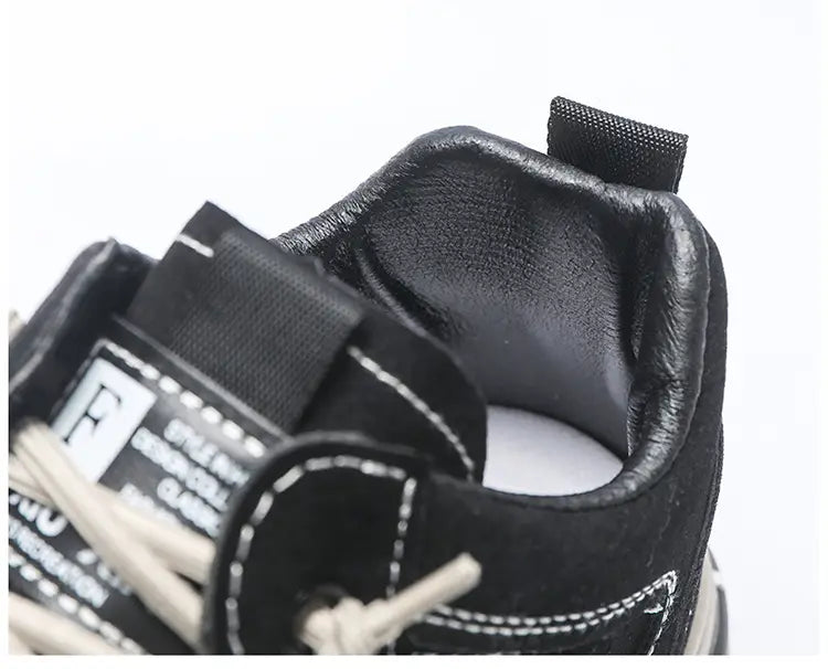 Zapatillas casual para hombre de plataforma transpirables en cuero negro, con costuras blancas y una correa de tela negra.